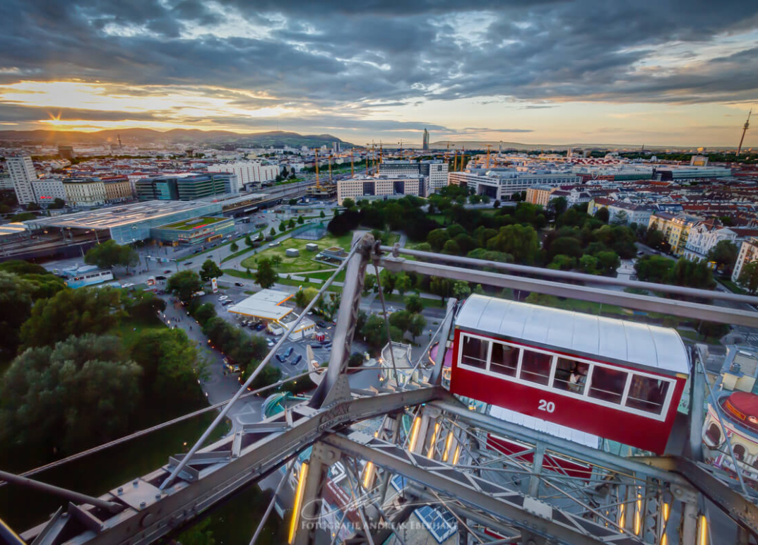 Blick vom Wiener Riesenrad auf die Stadt und den darunterliegenden Park bei Sonnenuntergang.